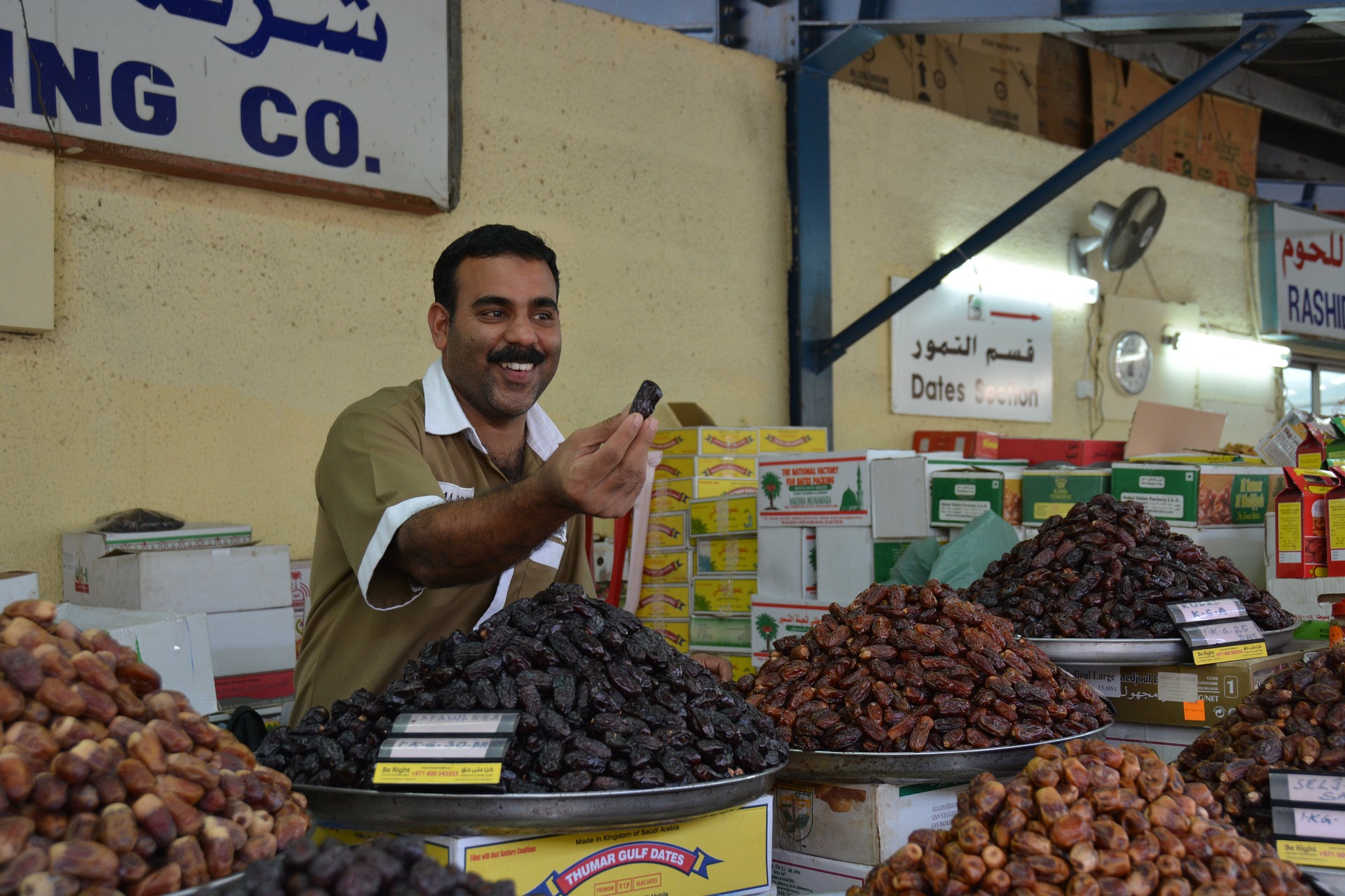 Ein Datteln Verkäufer auf einem Markt in Dubai. Bild von Franz P. Sauerteig auf Pixabay